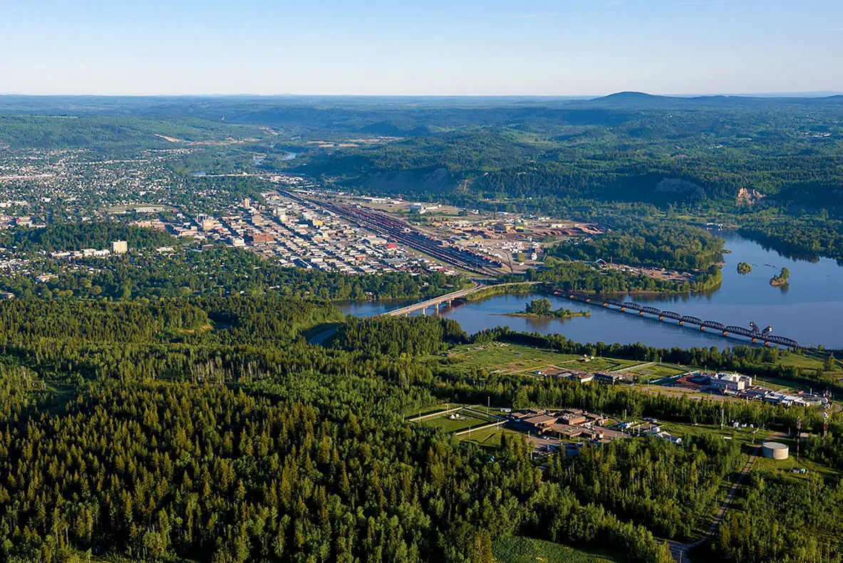 Prince George from a plane, with the river winding past the city and forest stretching to the horizon